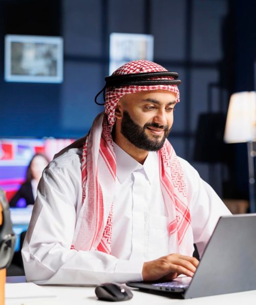 young-arab-man-works-diligently-his-desk-browsing-internet-his-digital-laptop-engrossed-online-webpage-he-takes-notes-researches-embodying-professionalism-efficiency_482257-70636
